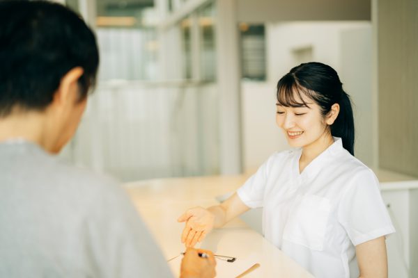 歯医者　受付する女性